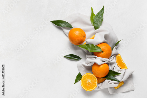 Fresh juicy oranges with leaves on white background