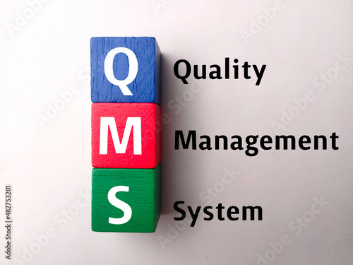 Top view colored block with text QMS (quality management system) on a white background. photo