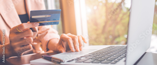 Obraz na płótnie Woman holding credit card and searching online with computer. w salonie