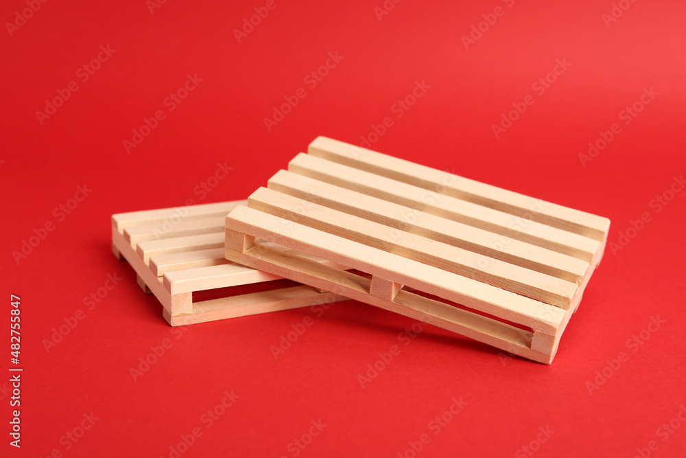 Two small wooden pallets on red background