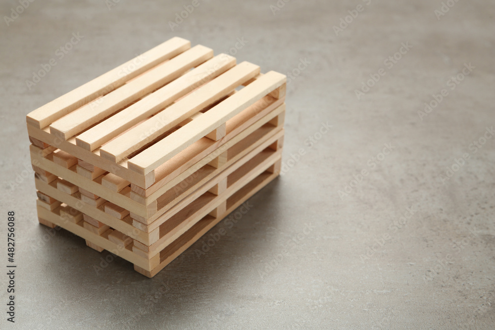 Stack of wooden pallets on light grey table, space for text Stack of wooden pallets on light grey table, space for text