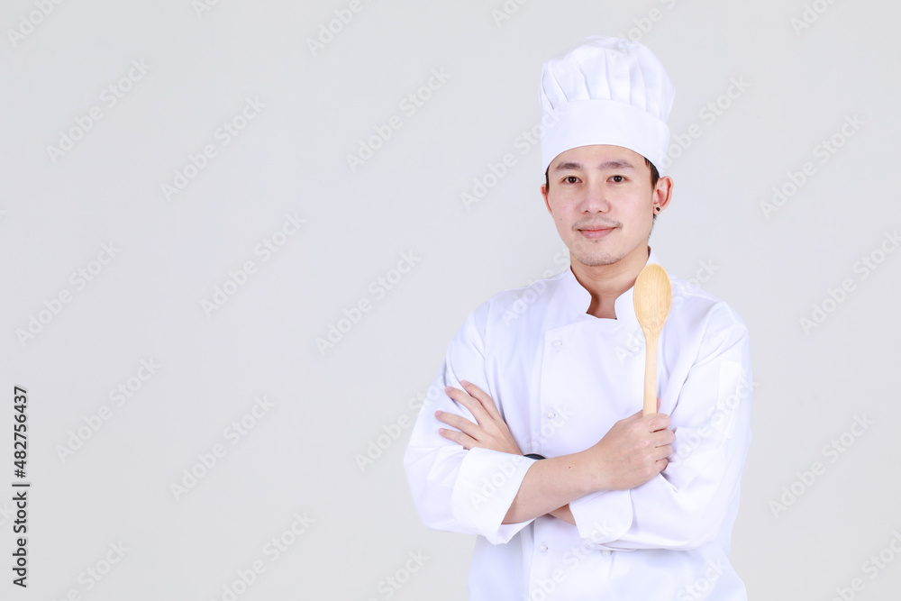 Experienced and smart chinese chef on elegant cooking uniform smile and standing confidently at kitchen with arm crossed and spoon as qualified expert of cuisine for luxurious dining Experienced and smart chinese chef on elegant cooking uniform smile and standing confidently at kitchen with arm crossed and spoon as qualified expert of cuisine for luxurious dining