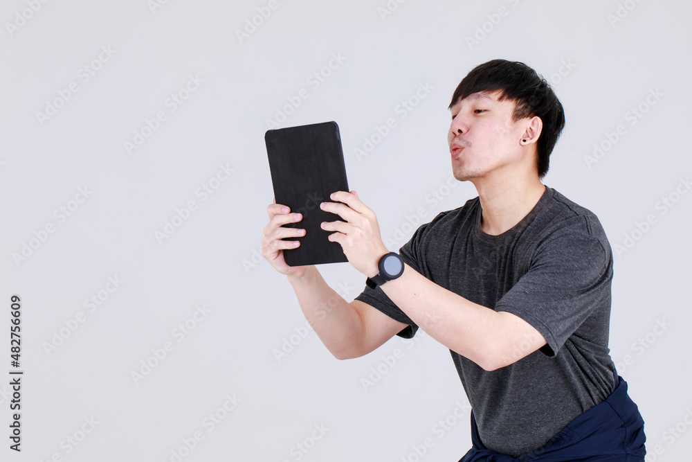 Smart young chinese guy on service uniform jacket holding tablet computer. Smart young chinese guy on service uniform jacket holding tablet computer.