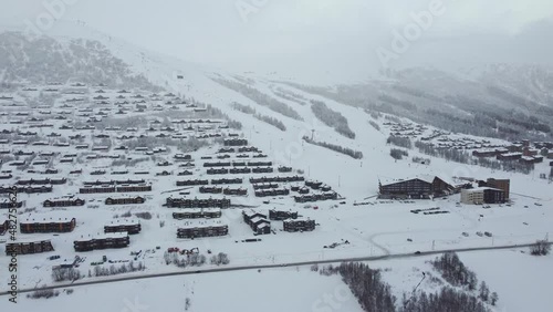 Early morning in Myrkdalen Norway - Famous ski destination and mountain village - Skilift running and cars starting to arrive - Aerial overview of snowy Myrkdalen photo