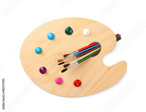 Wooden artist's palette with brushes and samples of paints isolated on white, top view