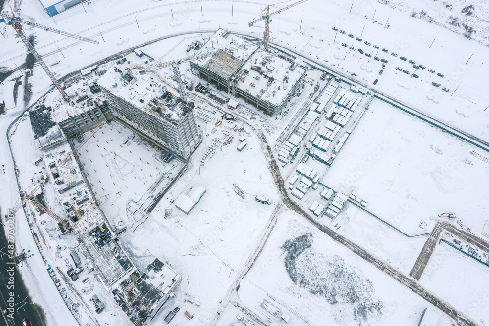 construction of high-rise apartment buildings in the winter. aerial top view from flying drone. construction of high-rise apartment buildings in the winter. aerial top view from flying drone.