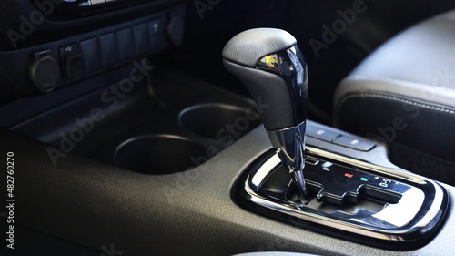 Automatic transmission inside a luxury and modern sports car. Closeup of automatic gear lever handles inside the car on dark background with copy space. Selective focus