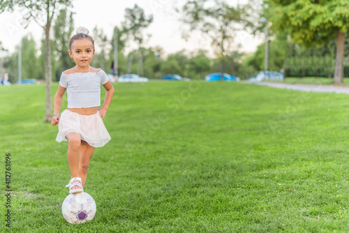 A little girl posing with soccer ball at park