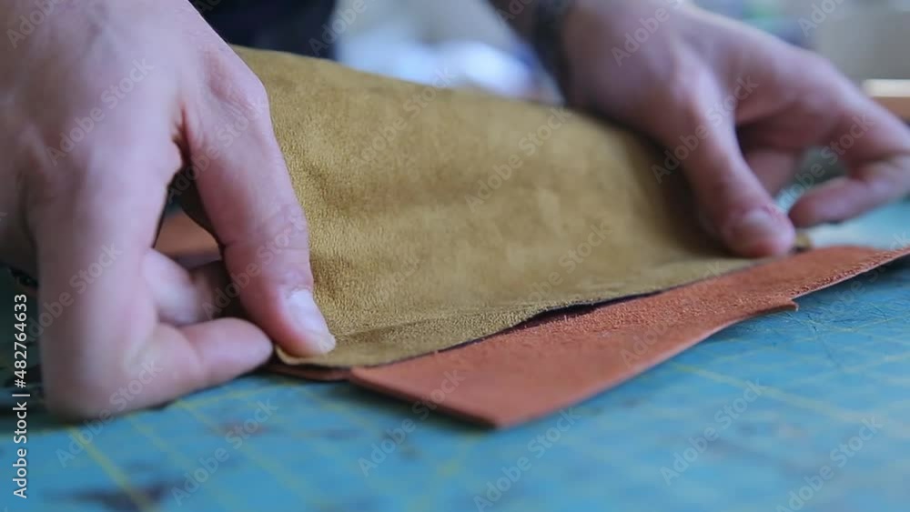 The craftsman sticks two pieces of leather together for the inner