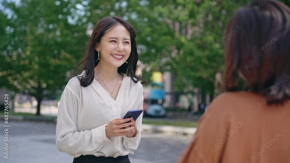 屋外でスマホを持って会話する女性 屋外でスマホを持って会話する女性