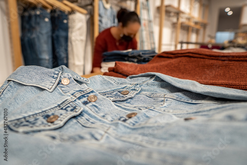 Woman folding clothes in a store in times of covid