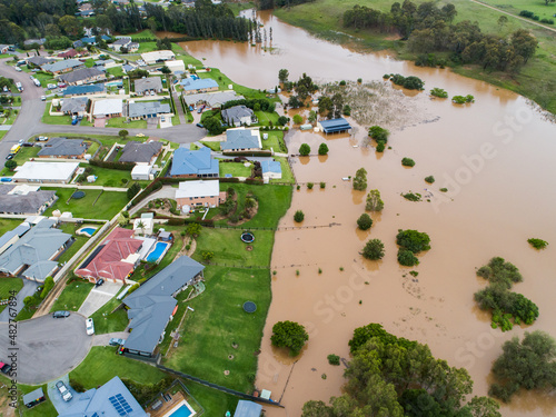 Backyards of homes full of brown floodwater from river backflow photo