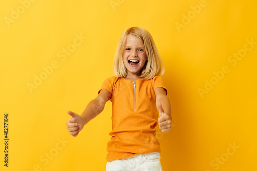 Little girl in a yellow t-shirt smile posing studio childhood lifestyle unaltered
