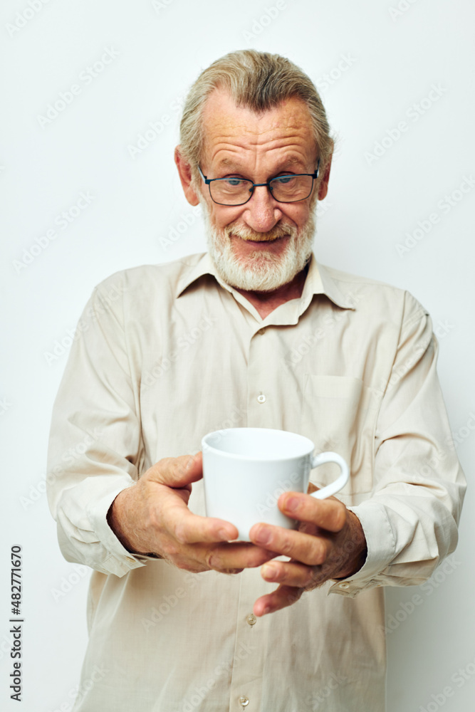 old man with glasses shows a mug on a white background old man with glasses shows a mug on a white background