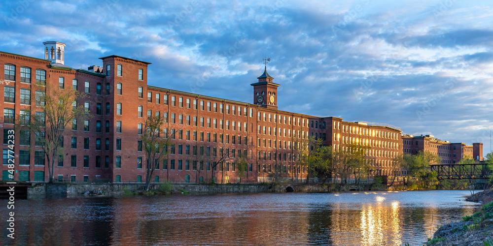 Sunset in Nashua. Historic cotton mill building with clock tower in Nashua Old Industrial Park. Nashua Corporation. Nashua Manufacturing Company, New Hampshire, USA