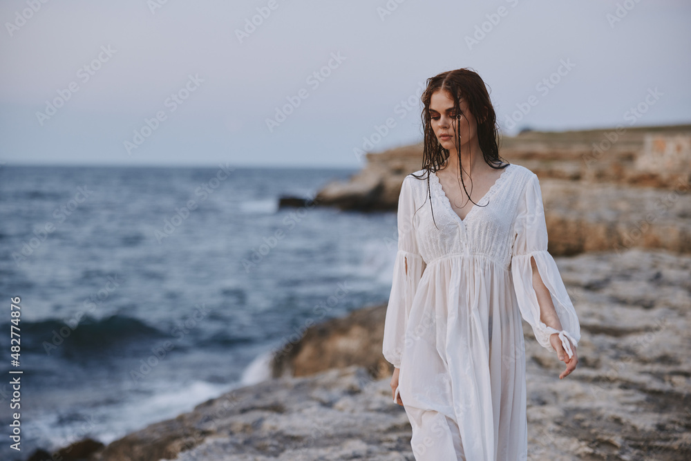 Attractive woman in white dress at the sea beach nature unaltered Attractive woman in white dress at the sea beach nature unaltered