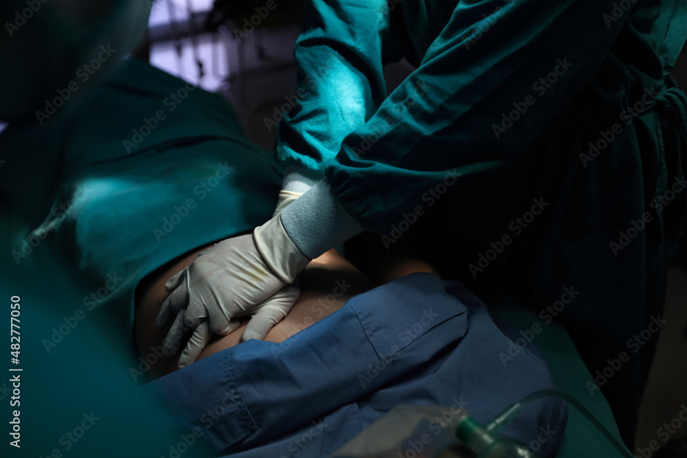 Closeup image of professional concentrated surgical team performing CPR on patient in hospital operating room or emergency room. Surgery concept Closeup image of professional concentrated surgical team performing CPR on patient in hospital operating room or emergency room. Surgery concept