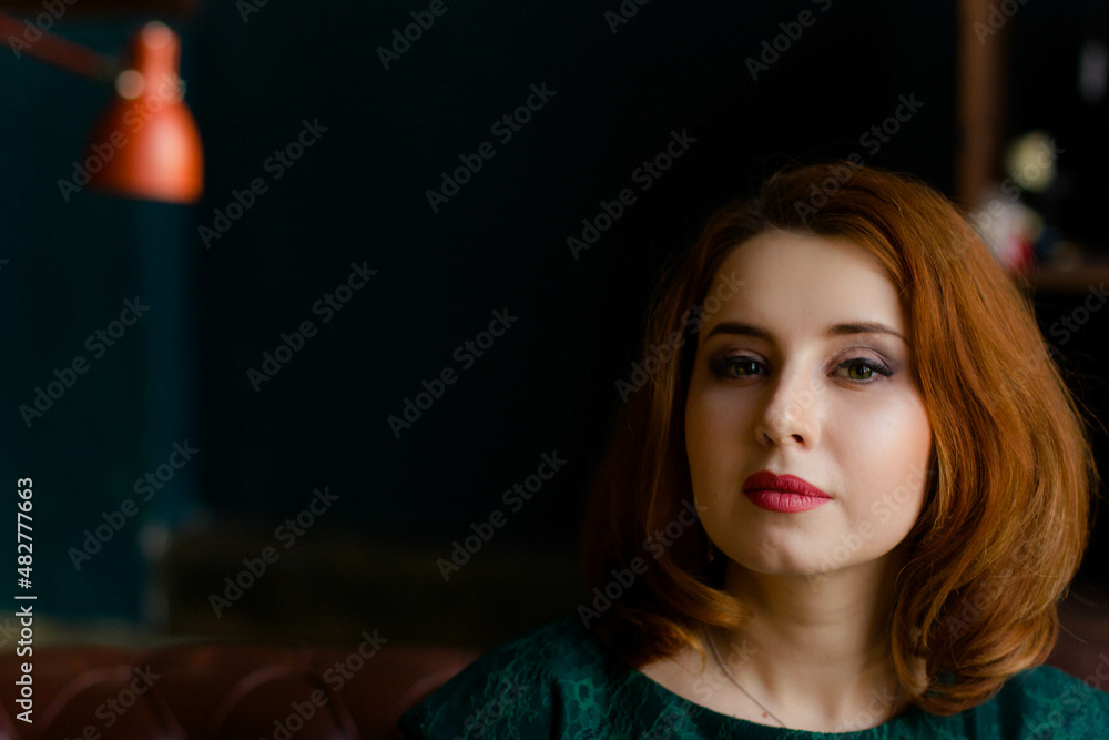 red-haired woman in green dress posing red-haired woman in green dress posing