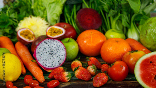 Top view close up shot of various kinds of healthy tasty nutritious fresh raw natural organic agriculture vegan vegetables and fruits ingredient diet placed on old colorful wooden table background