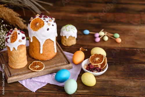 Easter holiday concept. Easter cakes (orthodox kulich), willow, painted eggs and candle on rustic wooden table