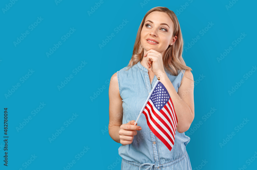 Portrait of a young smiling woman holding USA flag isolated on color background