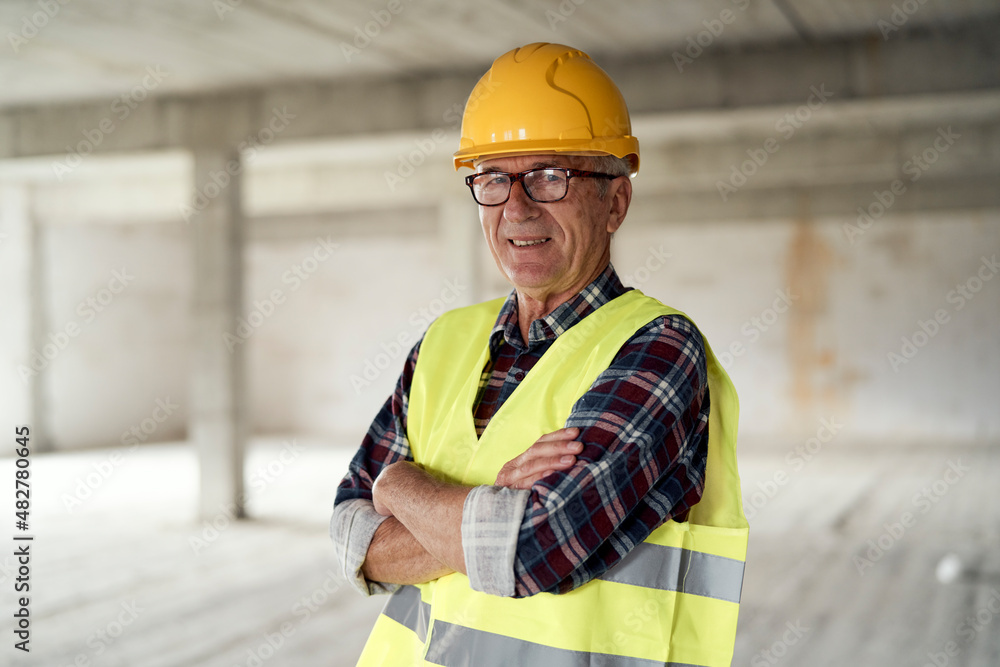 Senior caucasian man holding plans on the construction site Senior caucasian man holding plans on the construction site