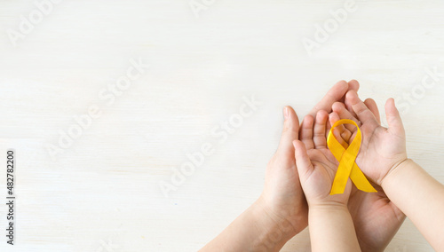 International Childhood Cancer Day. Mom and baby holding yellow ribbon in their hands. Sarcoma Awareness, bladder cancer. Leukemia cancer awareness. World Multiple Sclerosis day. I Am and I Will.