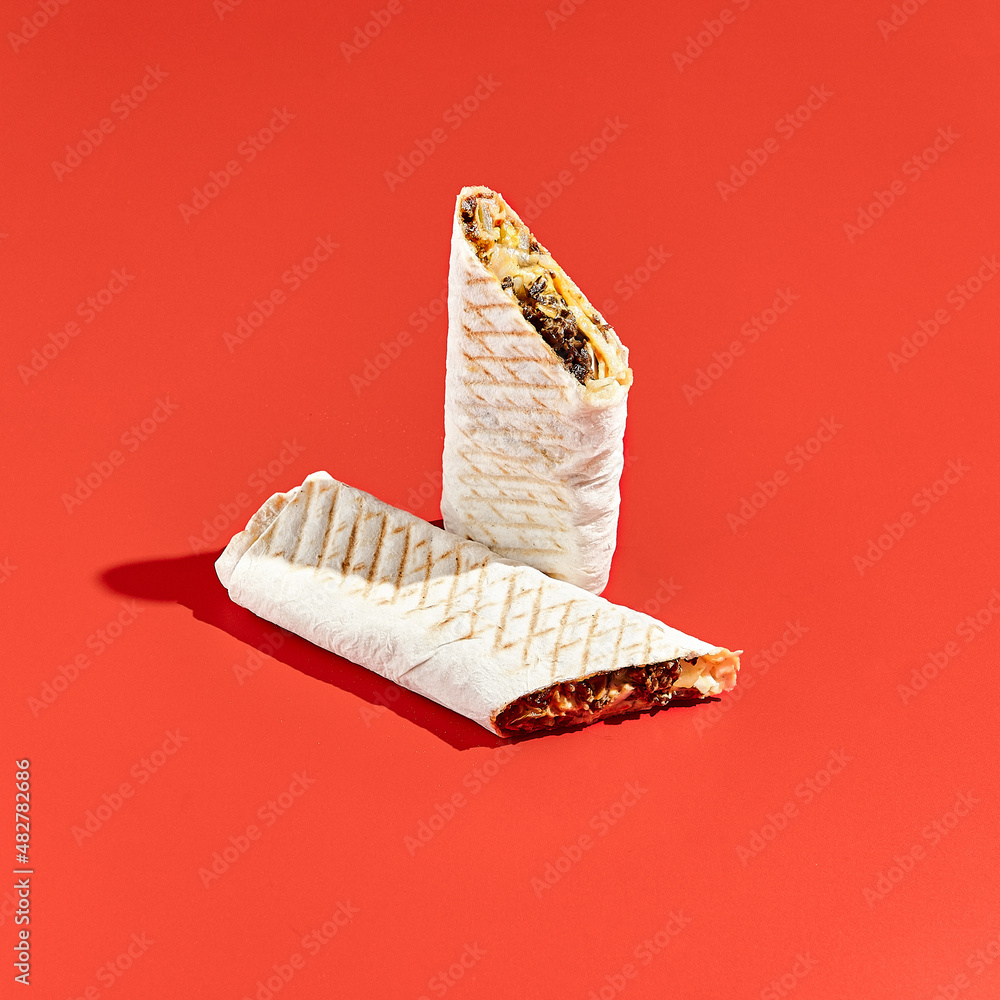 Shawarma wrap with beef on color background with hard shadow. Beef ...
