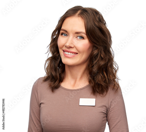 Foto sale, shopping and business concept - happy female shop assistant with name tag