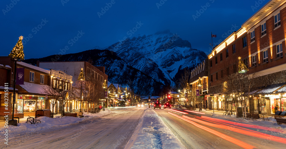 Town of Banff, Alberta, Canada - January 10 2022 : Downtown Banff Avenue in winter night. - obrazy, fototapety, plakaty 