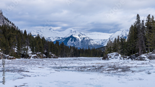 Frozen Bow River in winter, snowcapped Canadian Rockies in the background. Beautiful scenery in Banff National Park, Alberta, Canada. © Shawn.ccf