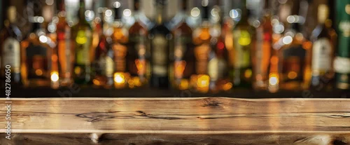 Panel kuchenny z motywem Wooden board and beautiful bokeh shelves with alcohol bottles at the background.