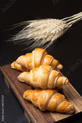 Fresh croissants on a wooden board. Freshly baked in morning.