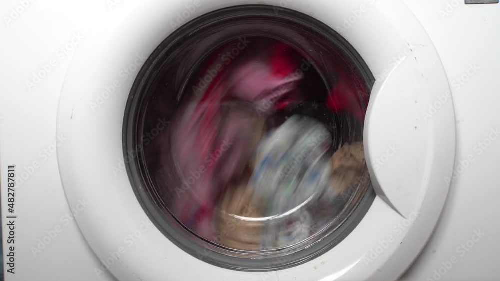 Washing dirty linen in the washing machine. Drum rotation. White body. Household appliances. Bathroom. Clean linen. Close-up. Washing dirty linen in the washing machine. Drum rotation. White body. Household appliances. Bathroom. Clean linen. Close-up.