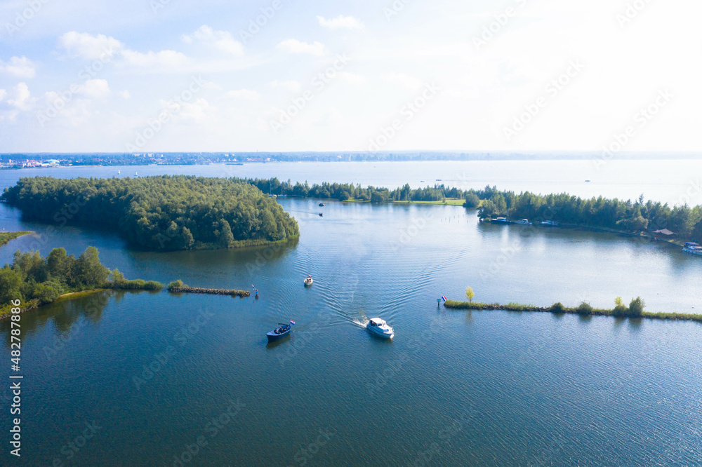 Aerial view of the Wolderwijd lake with small green islands that offer shelter to various species of fish and birds. Dutch province of Flevoland, Netherlands. Aerial view of the Wolderwijd lake with small green islands that offer shelter to various species of fish and birds. Dutch province of Flevoland, Netherlands.