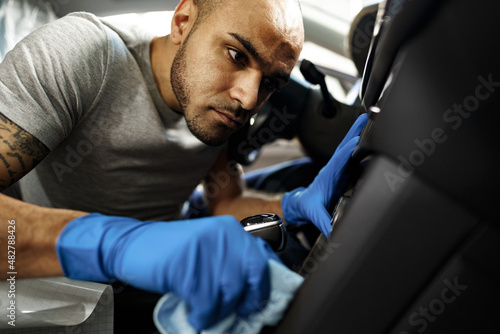 A man cleaning car interior, car detailing in Carwash service
