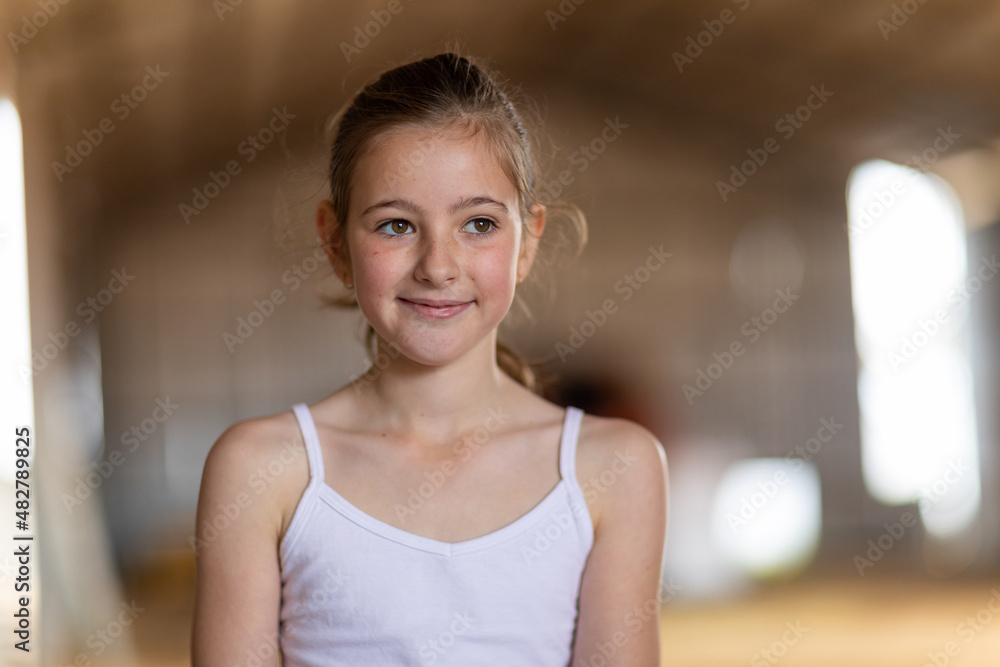 head and shoulders of child wearing white singlet in big farm shed head and shoulders of child wearing white singlet in big farm shed