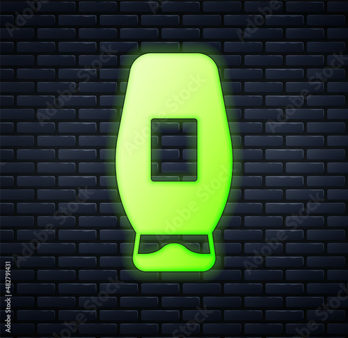 Glowing neon Bottle of shampoo icon isolated on brick wall background. Vector