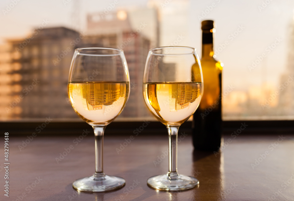 two glasses of wine and a city view 