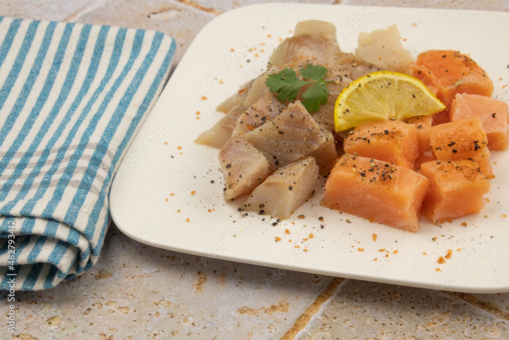 cut salmon and coalfish on a white background with parsley and lemon on a table cut salmon and coalfish on a white background with parsley and lemon on a table