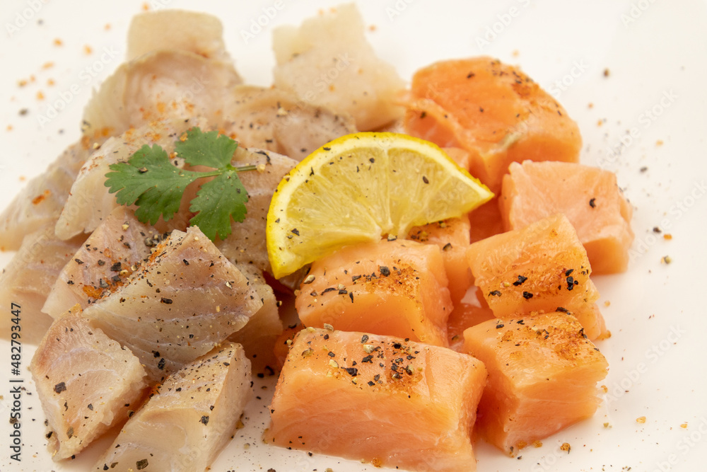 cut salmon and coalfish on a white background with parsley and lemon cut salmon and coalfish on a white background with parsley and lemon