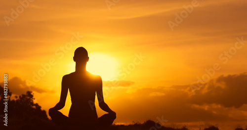 Fototapeta Naklejka Na Ścianę i Meble -  silhouette of a person meditating on a hill facing the sunset
