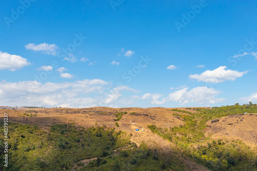 yellow grass mountain range with bright blue sky at morning from flat angle