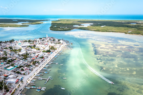 Aerial landscape overlooking the city of Rio Lagartos. The city is surrounded by a beautiful river with azure water. Fishing boats are moored to the shore. Yucatan, Mexico photo