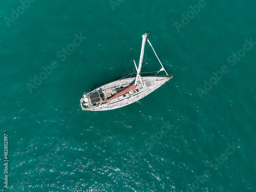 Aerial drone bird's eye view photo of huge white sail boat cruising in open deep blue sea