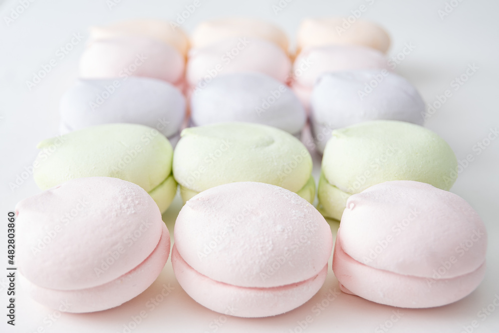 Delicate pattern of multi-colored pastel marshmallows on a light background, macro. Pastel marshmallows as a background Delicate pattern of multi-colored pastel marshmallows on a light background, macro. Pastel marshmallows as a background