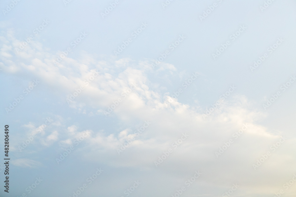 Pale blue sky with small clouds