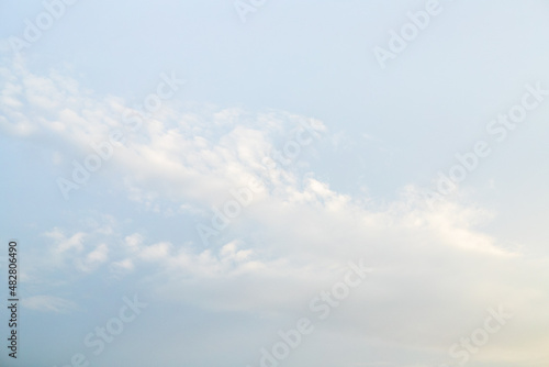 Pale blue sky with small clouds