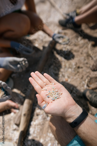 Voluntarios recogiendo plástico en la playa. Ecologismo en las playas. Microplasticos