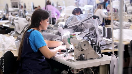 A seamstress works at a sewing factory. sewing production. Home textile production. Large sewing workshop photo